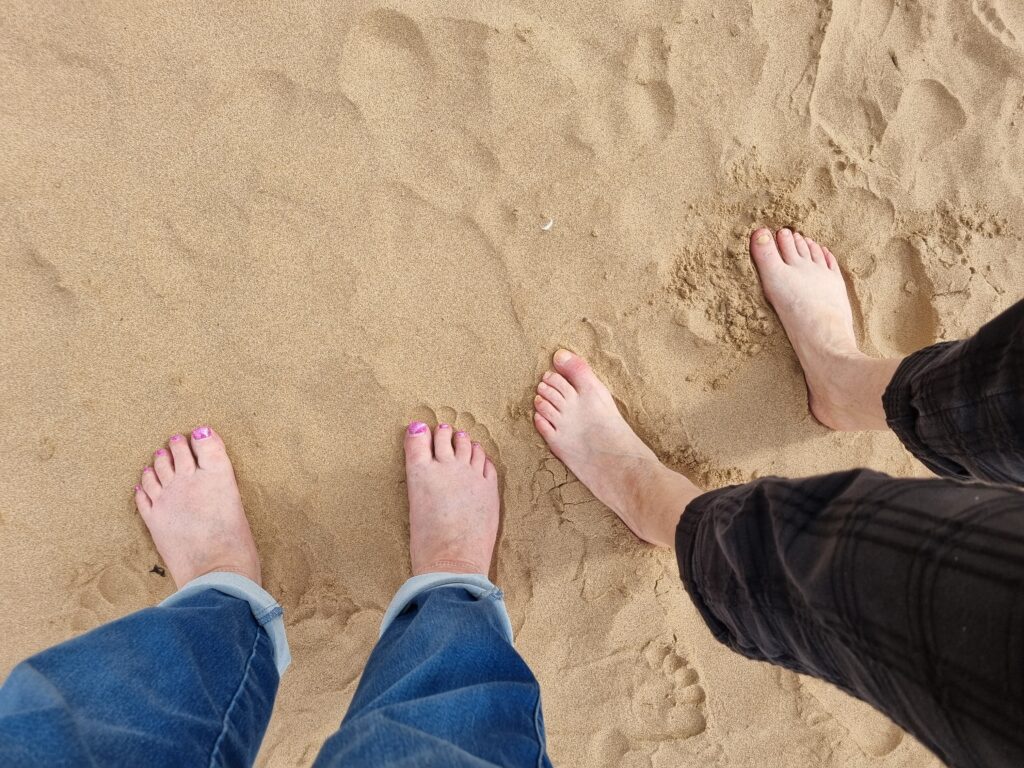 Relationship counselling. Bare feet standing on the beach.